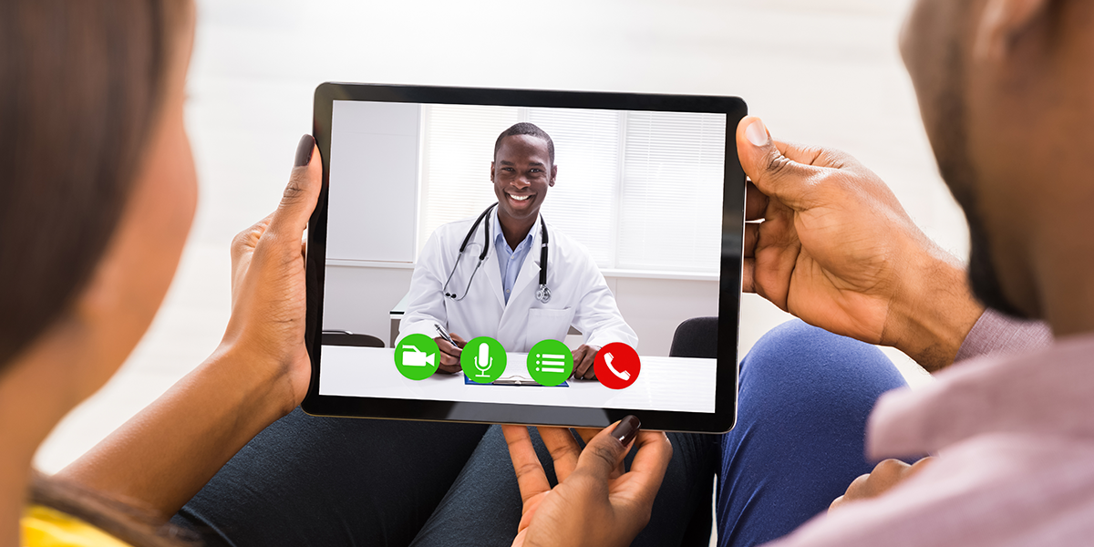 black provider on tablet screen with patient on a telehealth appointment