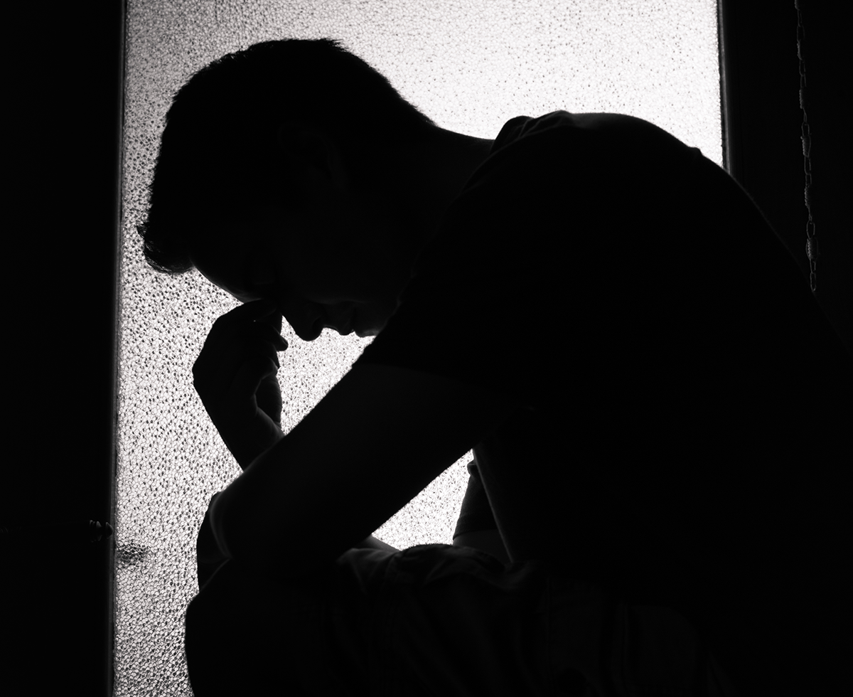 Silhouette of young man feeling sad